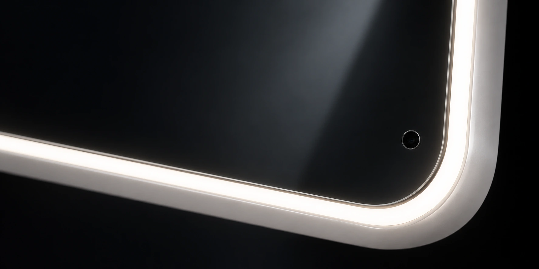 Macro studio view of Shine Mirror’s continuous illuminated surround curving around the reflective glass and a discreet camera